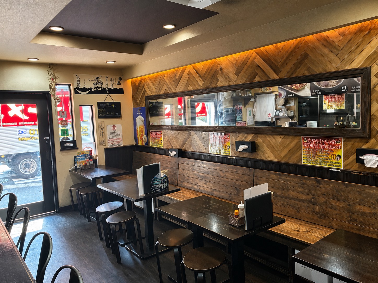 木目の壁とテーブル席が並ぶ春吉店内