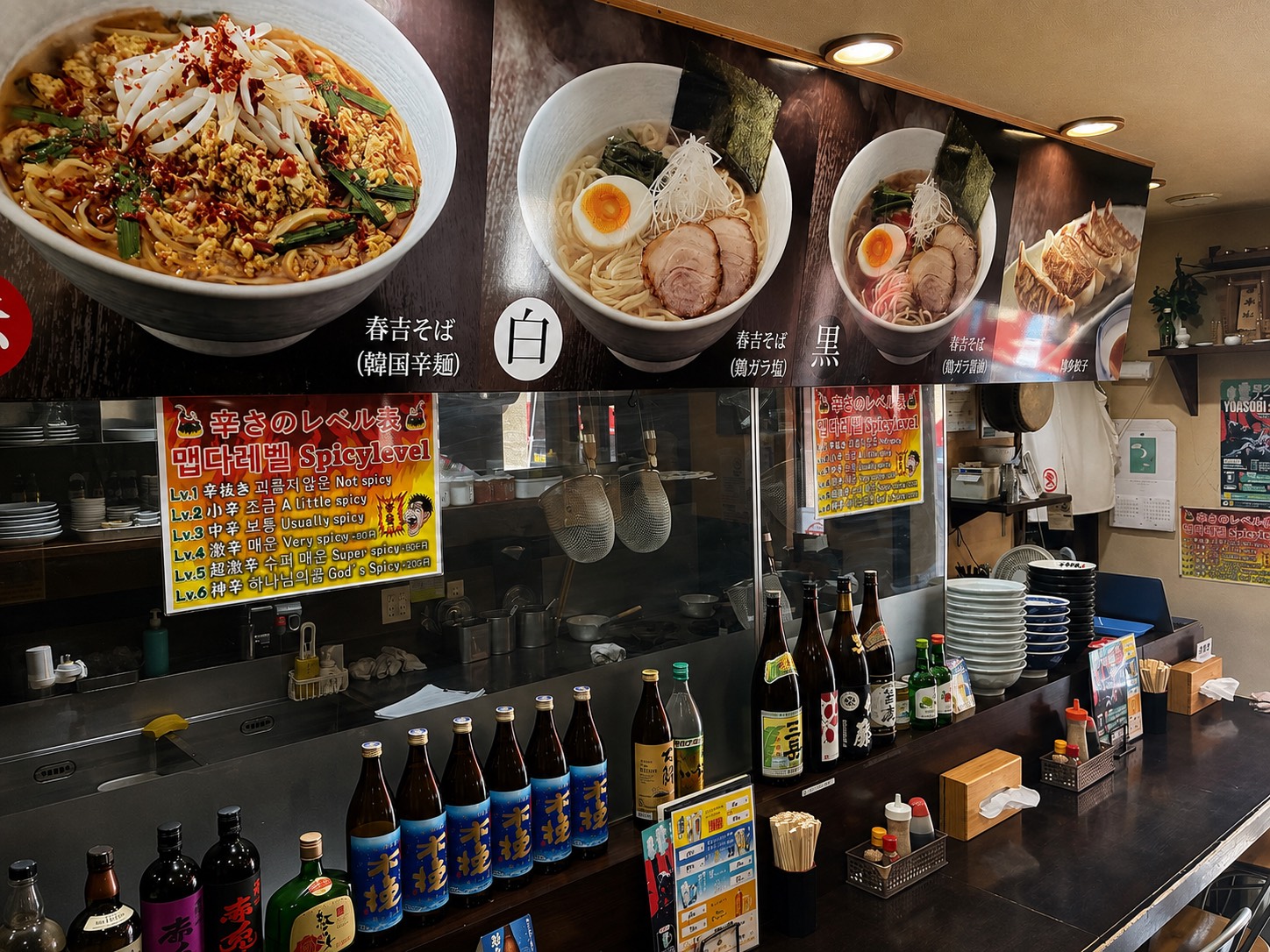 カウンター越しに厨房とメニューが見える春吉店内